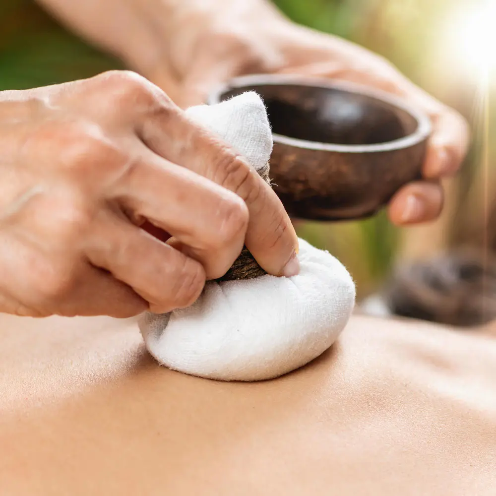 Traditional herbal compress massage using warm herbal pouches